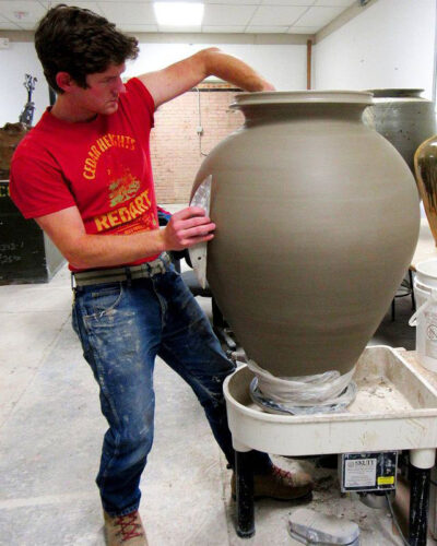 Herrick Smith throwing a large clay pot. 