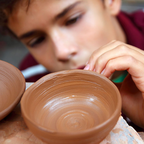 Kids Need Clay - kid with ceramic bowl